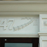 Door detail showing frieze, address panel, and ogee moulding.